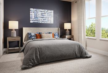 a bedroom with a gray bedspread and blue and orange pillows